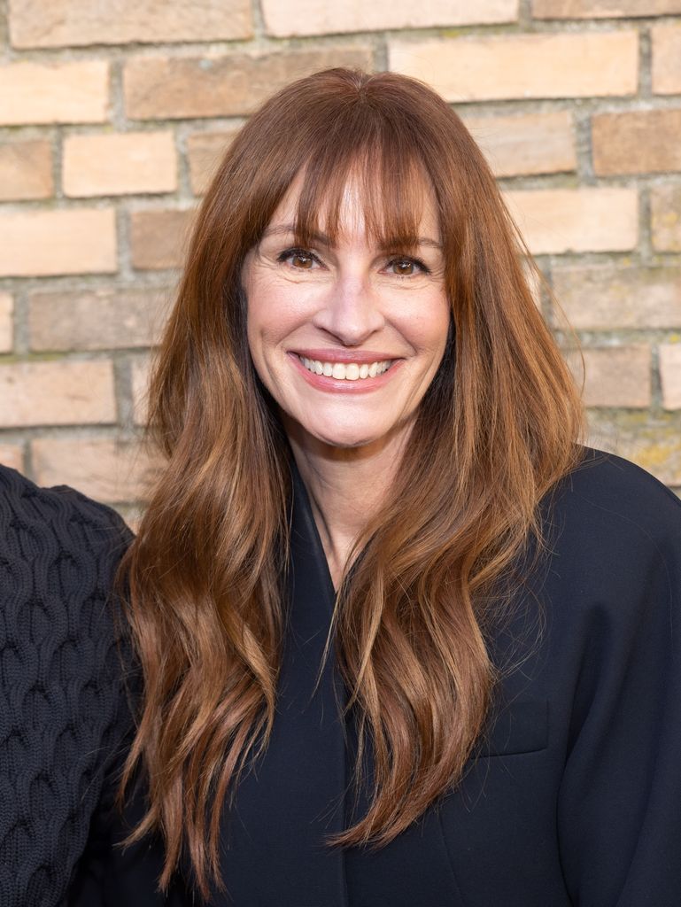 Julia Roberts standing in front of a brick wall