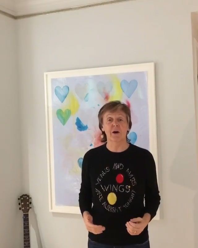 sir paul mccartney standing in front of colourful print 