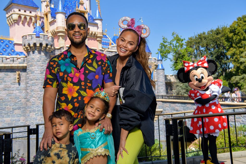 John Legend, Chrissy Teigen and their children Miles and Luna pose with Minnie Mouse