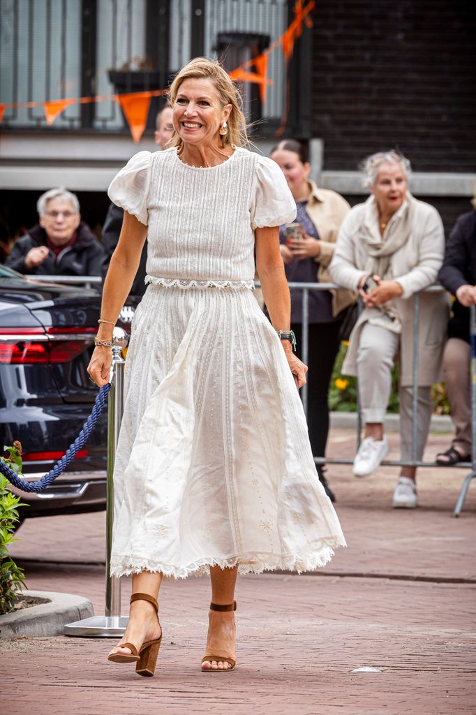 Queen Maxima of The Netherlands visits Sisters at a former monastery, wearing a white dress and heels