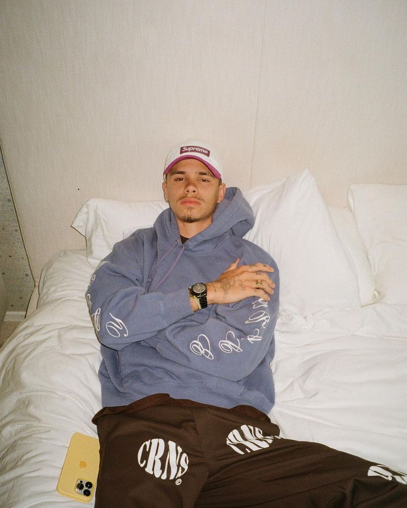 Romeo Beckham posing on a white bed