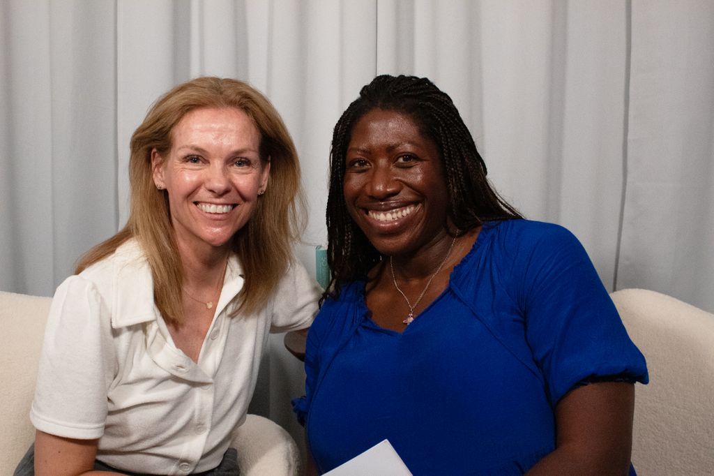 two woman smiling in a podcast studio 