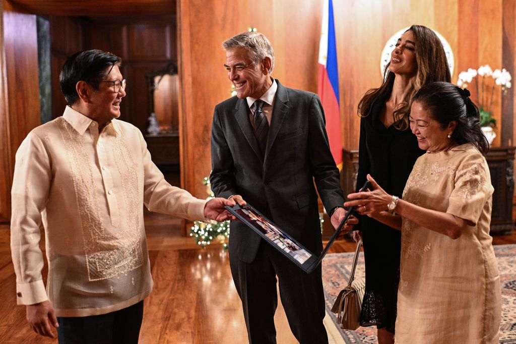 George Clooney (2L) and Amal Clooney (2R) receive a photo souvenir from Philippine President Ferdinand Marcos Jr. 