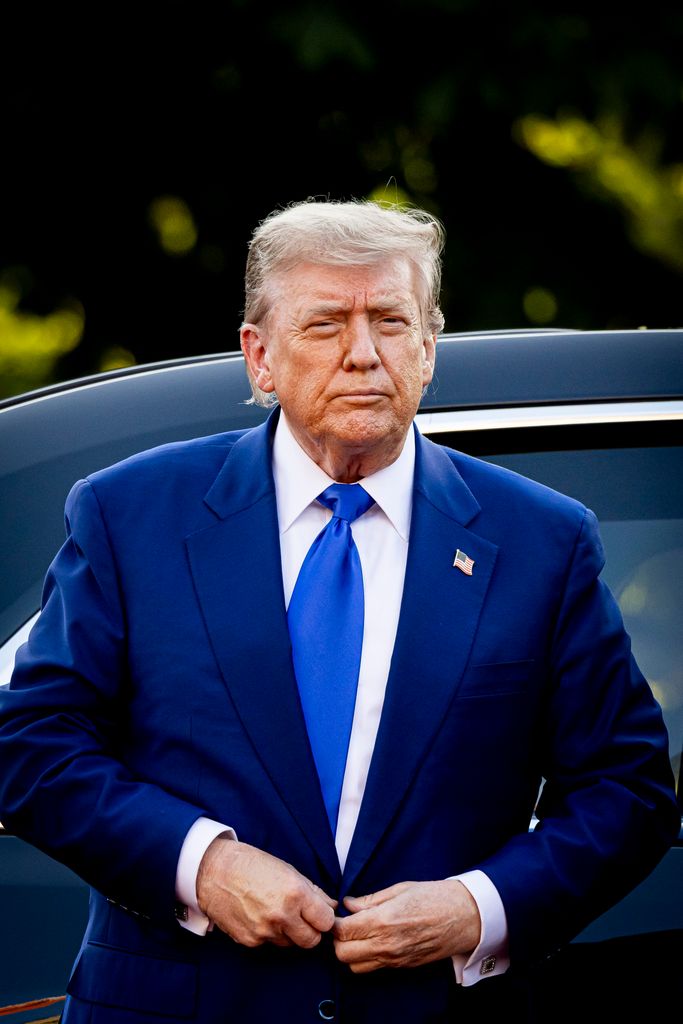 Donald Trump exiting car in blue suit