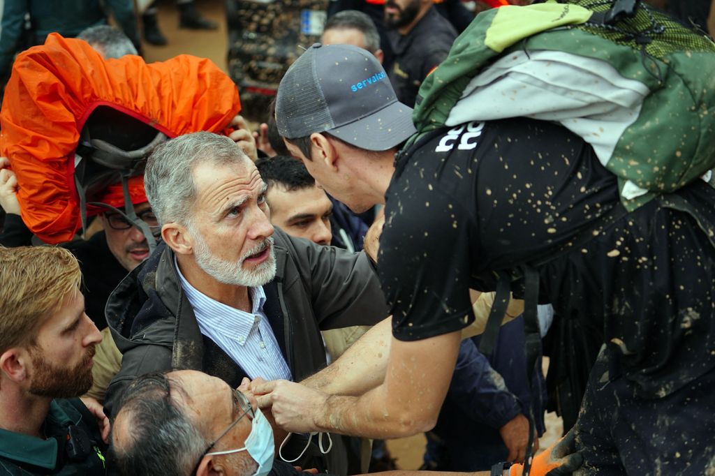 King Felipe speaking to a muddy man in Valencia