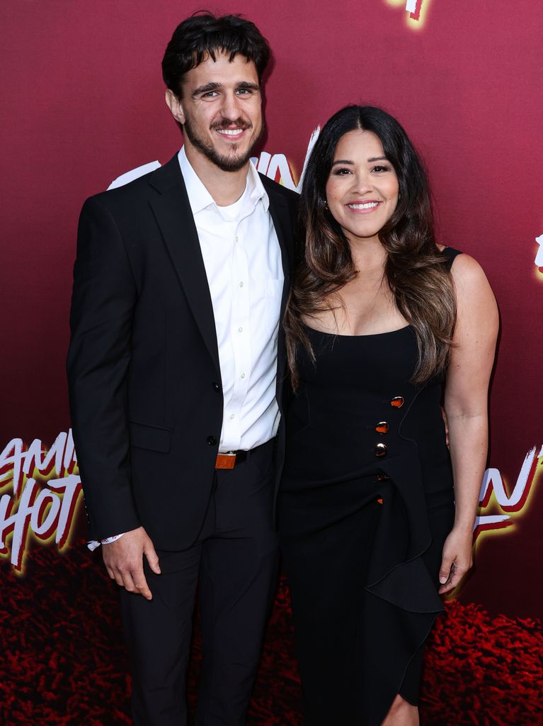 Man and woman smiling on red carpet 