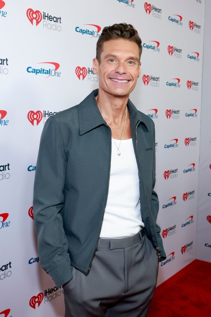 Ryan Seacrest in gray jacket and white t-shirt