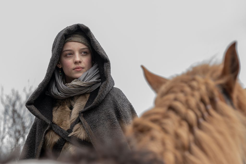 woman wearing grey hood on horse