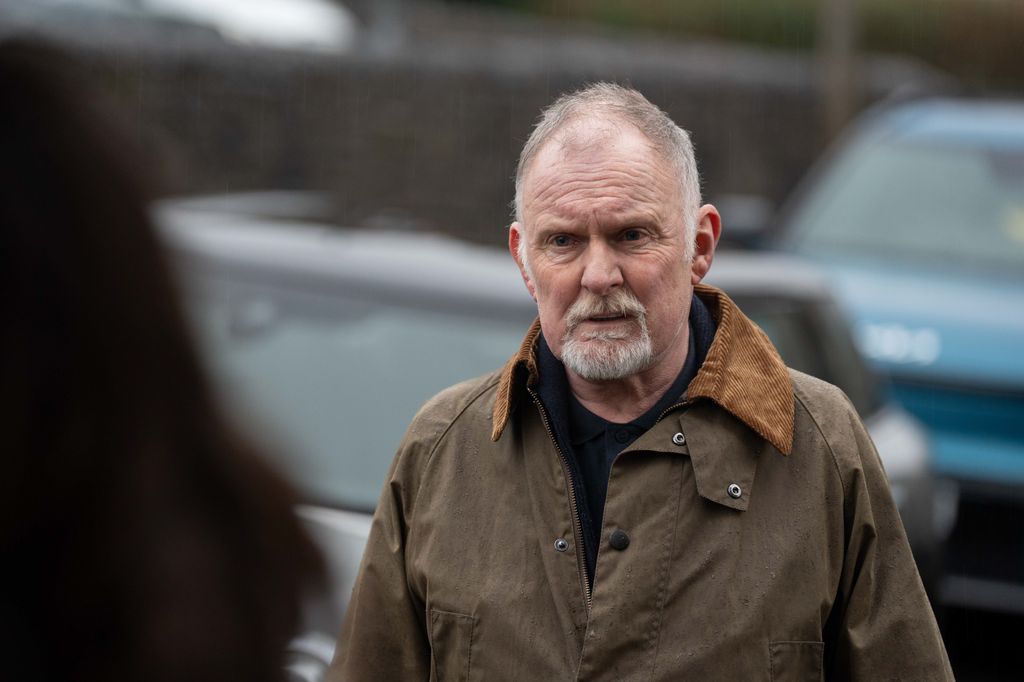 close up of man standing in front of cars