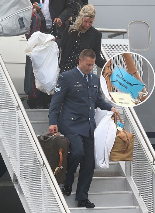 people walking down the steps of a plane carrying royal luggage