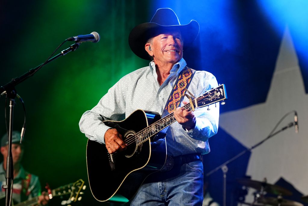 George Strait singing on stage with his guitar