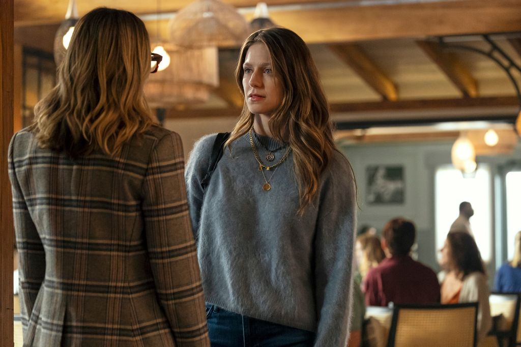 woman in grey jumper looking at other woman in restaurant