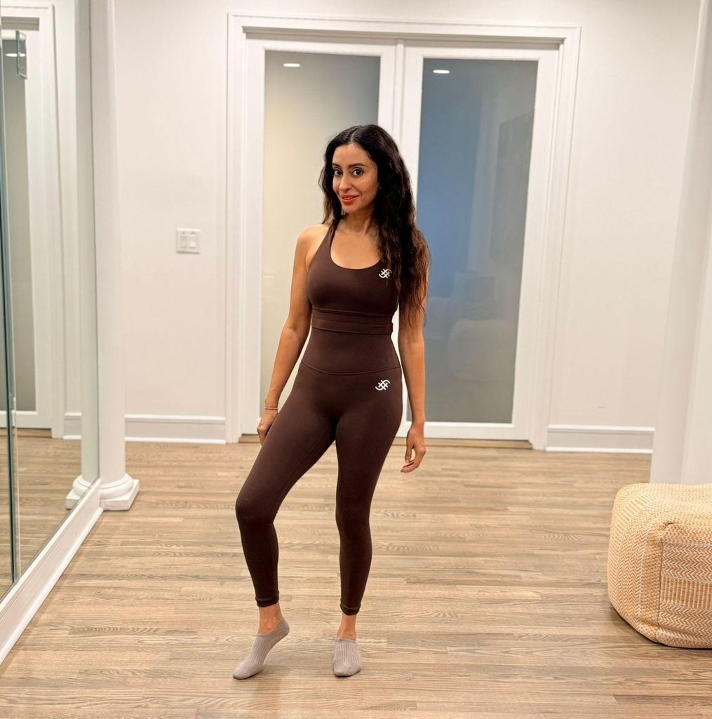 Slim brunette woman in a brown all in one outfit