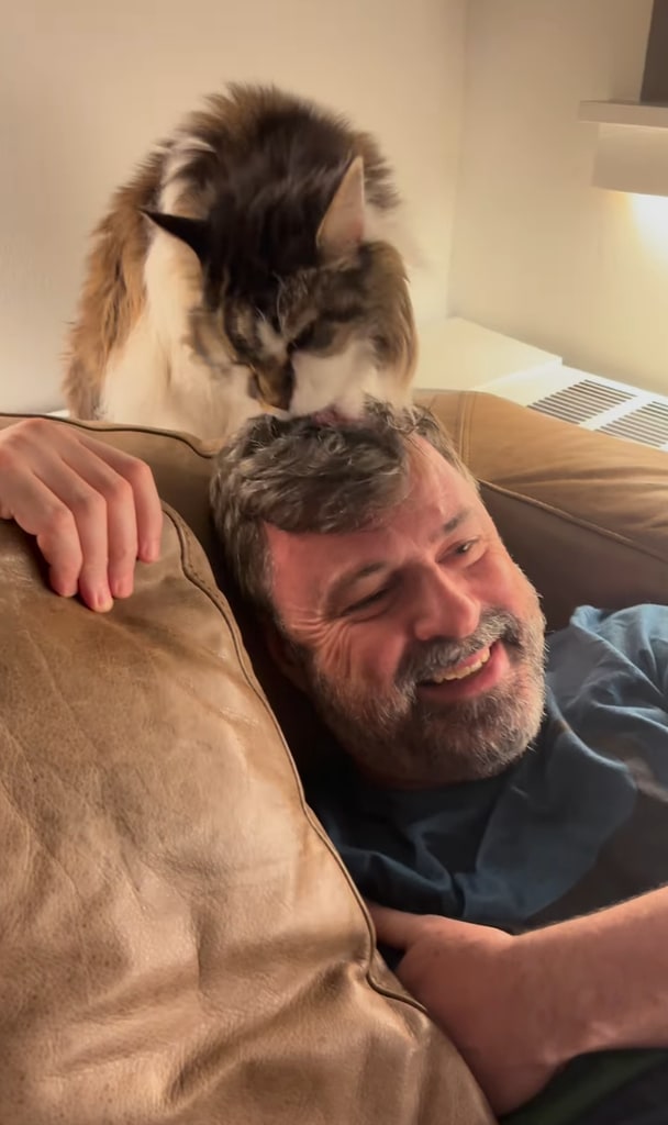Still from a video shared by Anne Burrell of her husband Stuart Claxton with one of their cats