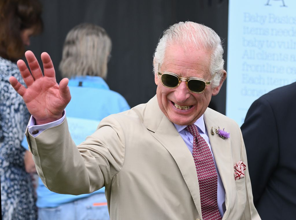 King Charles III smiling and waving at Sandringham Flower Show 2023