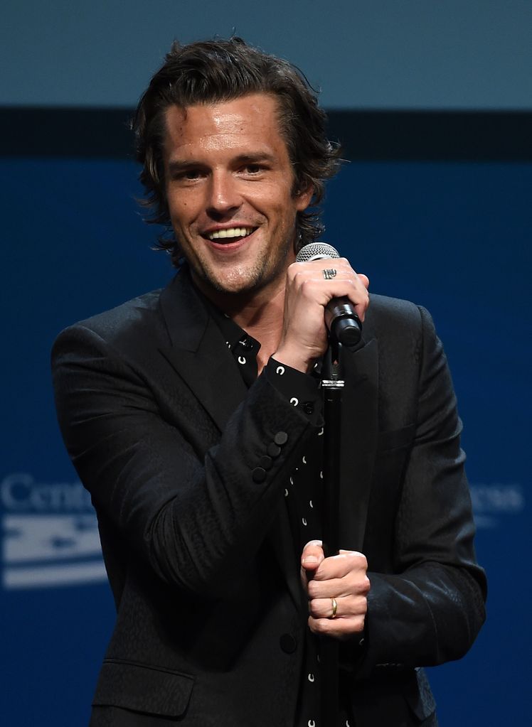Brandon Flowers in all black with a microphone
