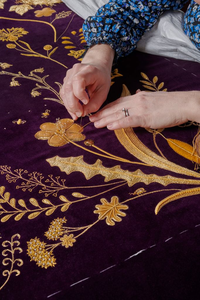 Hands working on embroidered robes