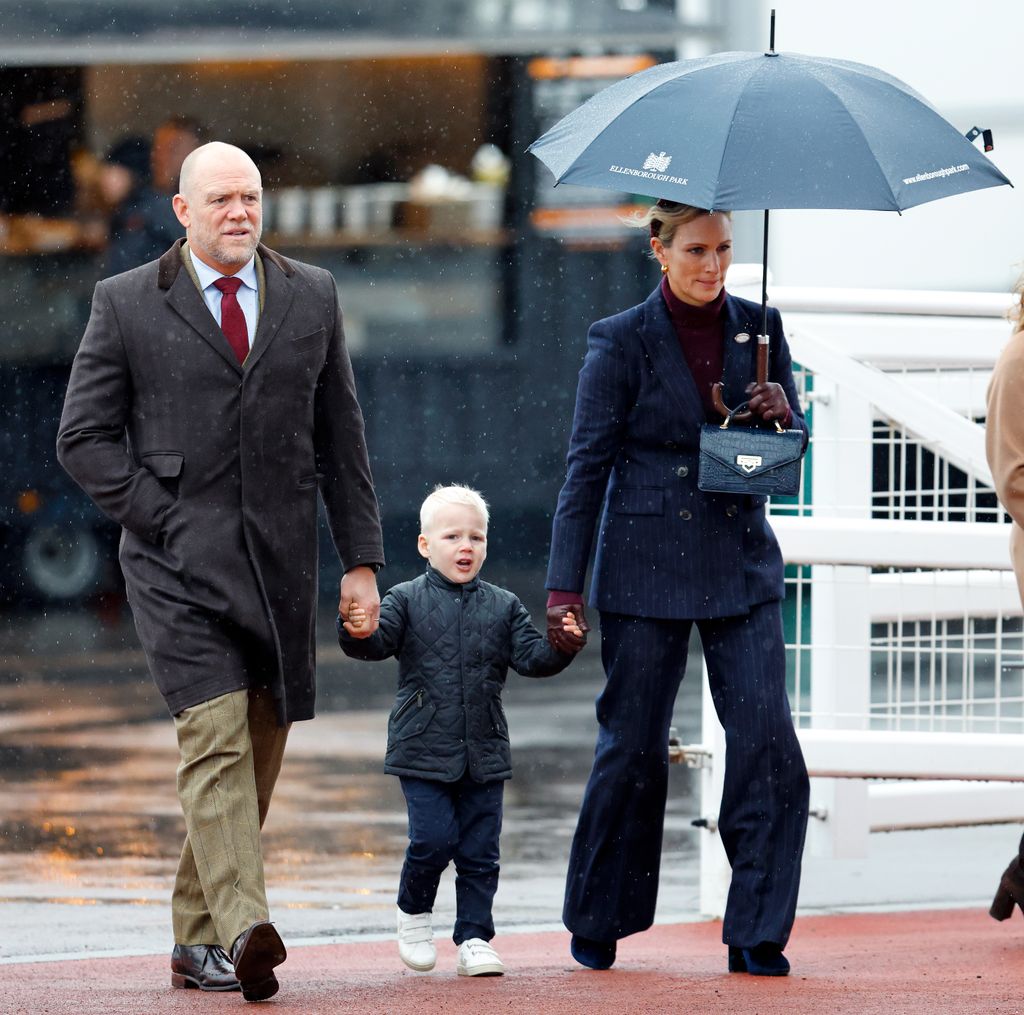 Mike Tindall, Lucas Tindall and Zara Tindall walking in rain