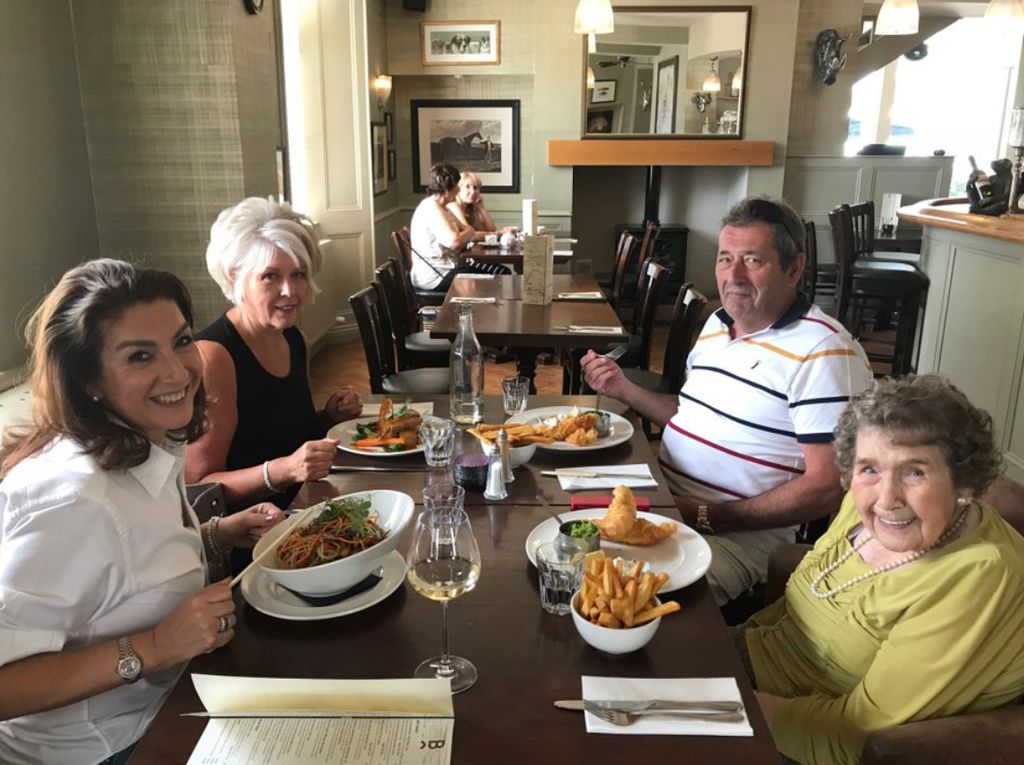 Jane McDonald assise à une table avec son frère, sa sœur et sa mère