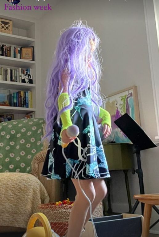Young girl in black dress and purple wig