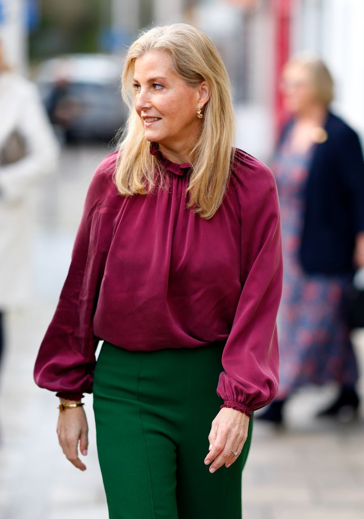 The royal rocked a plum-hued blouse with bold green trousers