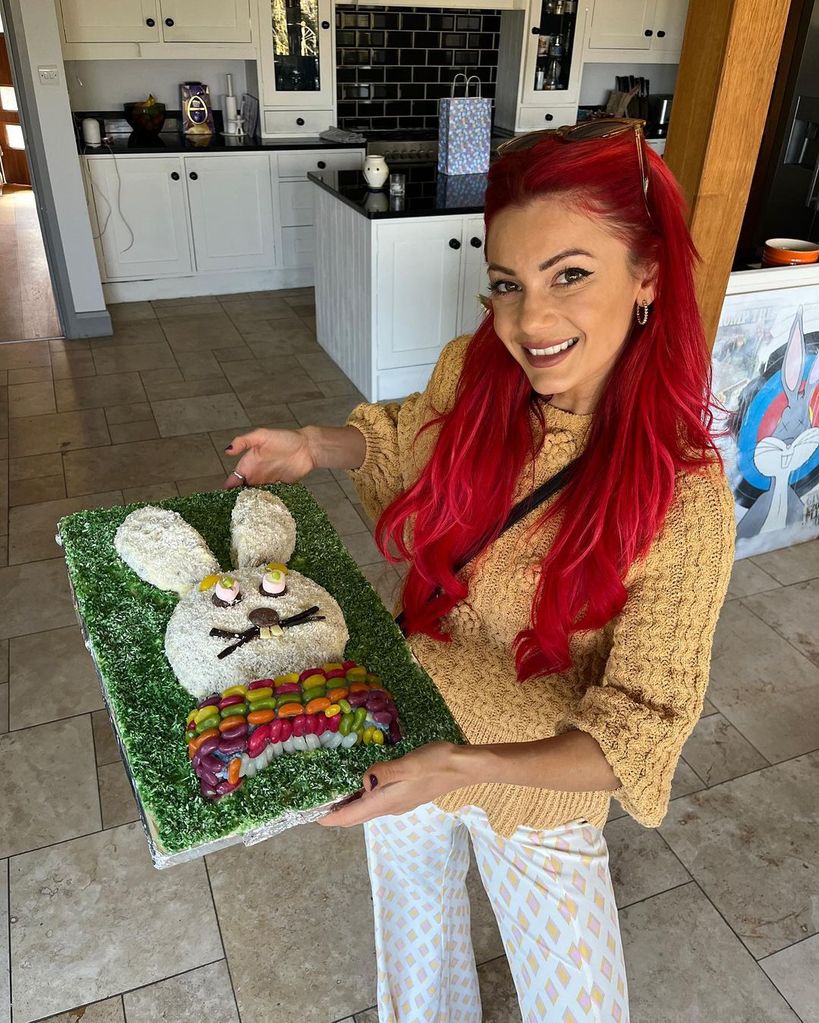 Dianne buswell showing off long curly red hair holding easter bunny shaped cake