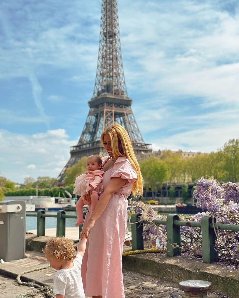 stacey solomon holding daughter belle and rose posing in front of eiffel tower