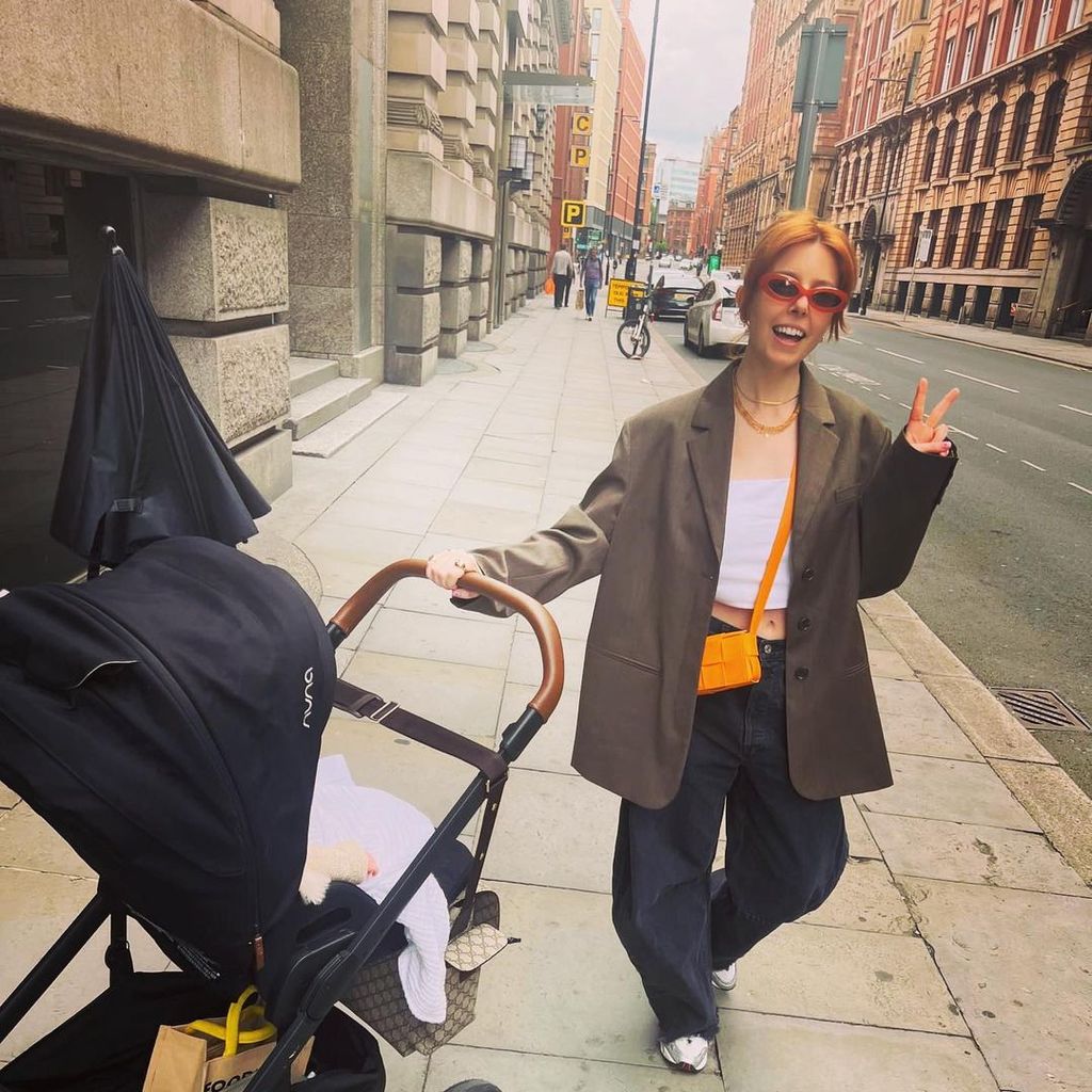 Stacey Dooley pushes daughter Minnie in a pram