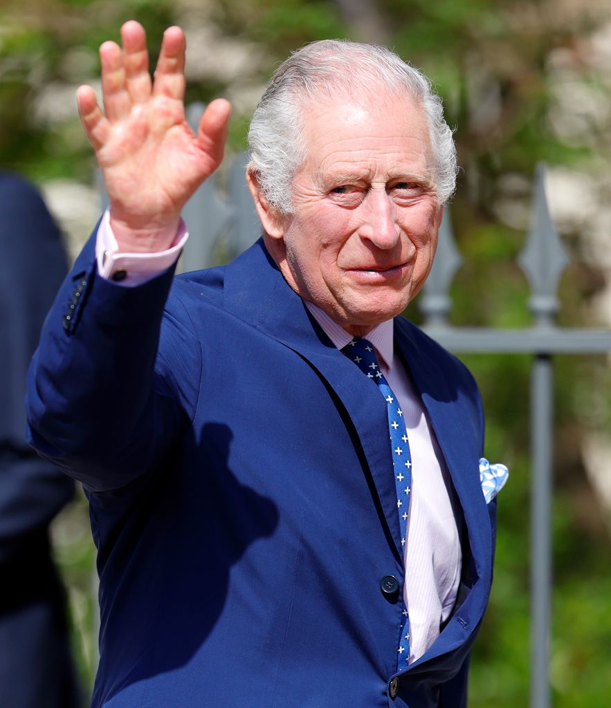 King Charles III waving and smiling