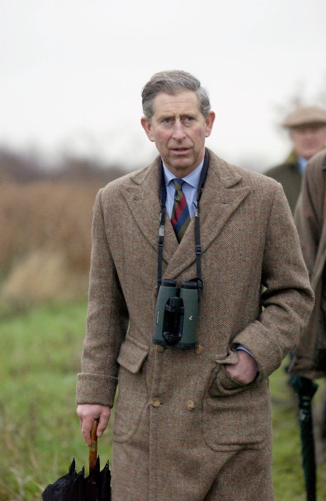 king charles in norfolk wearing coat and binoculars 