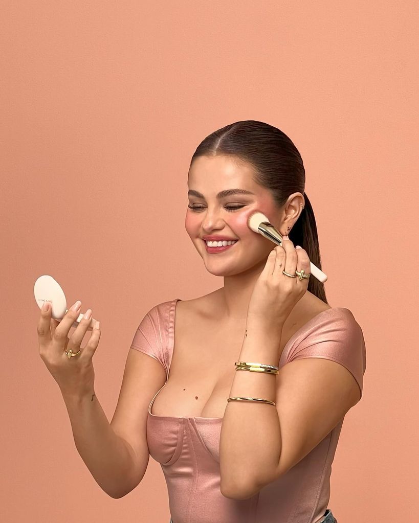 Selena Gomez posing with Rare Beauty 