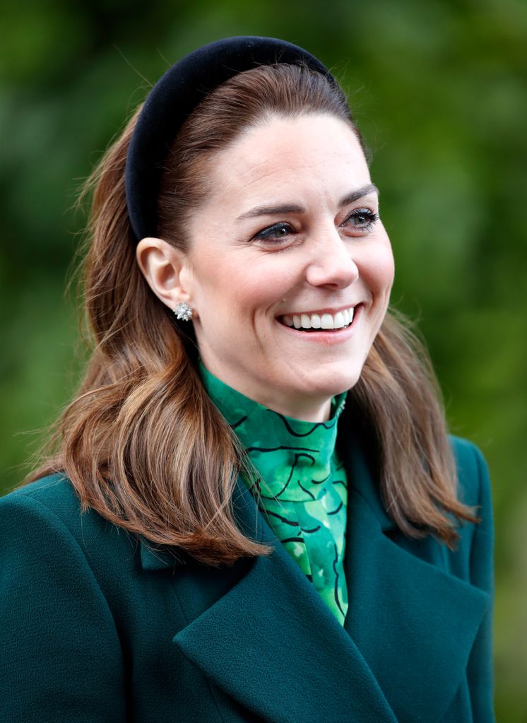 Kate Middleton in green dress and velvet headband smiling while meeting The President of Ireland, Michael D. Higgins