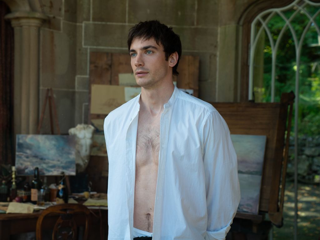 A man stands with his shirt open