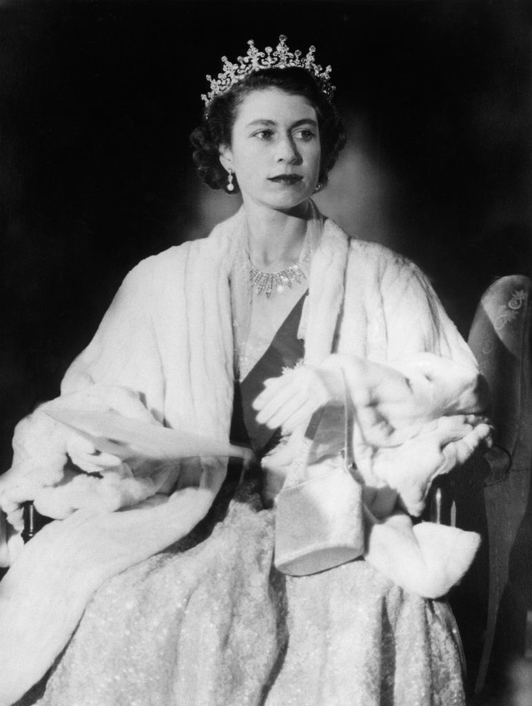 A young Queen Elizabeth II is elegantly dressed in a fur stole and tiara. Her expression is poised and regal, embodying her early royal image.