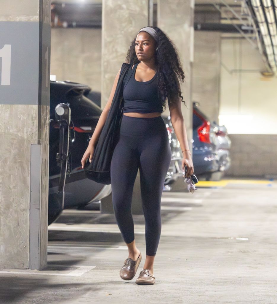 Sasha wearing leggings and a crop top with curly hair