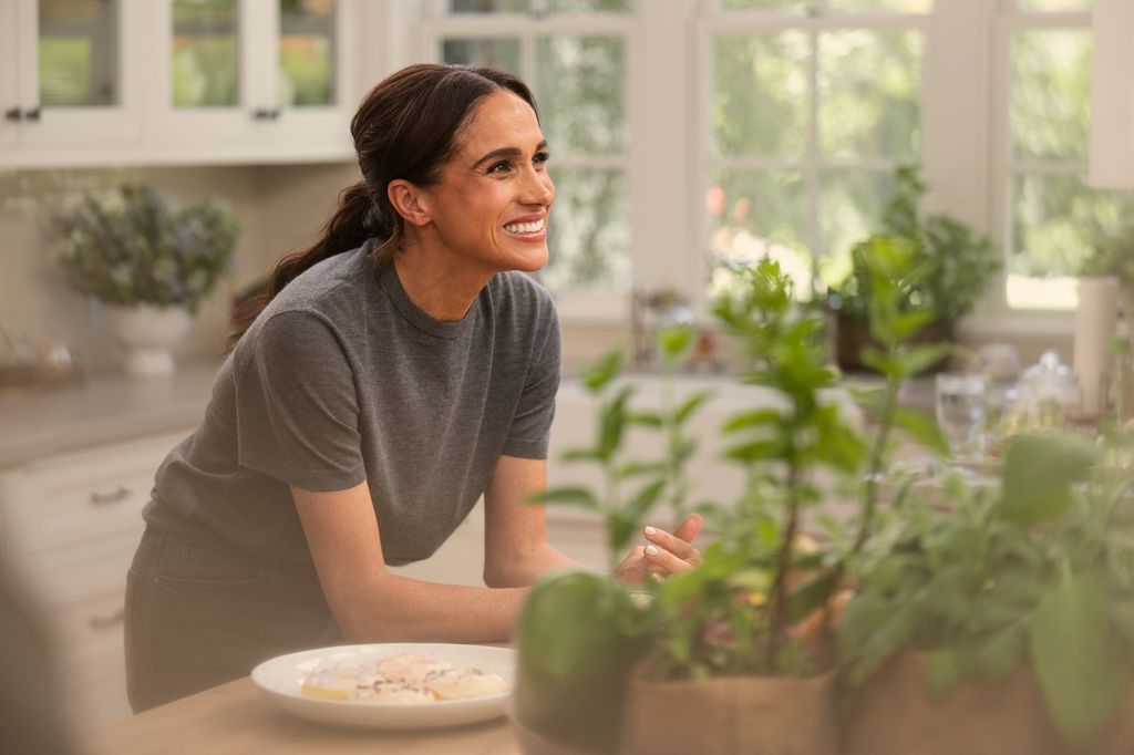 Meghan, Duchess of Sussex in episode 103 of With Love, Meghan leaning on the island and looking at some-one off-camera