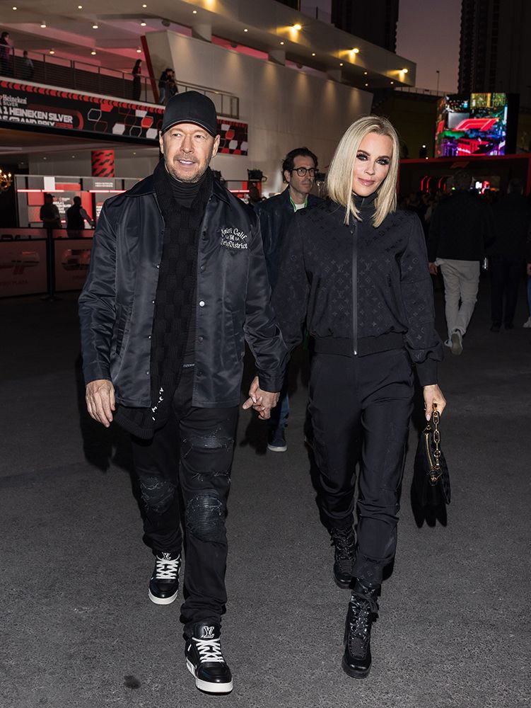 Jenny McCarthy and Donnie Wahlberg holding hands as they walk around the circuit 