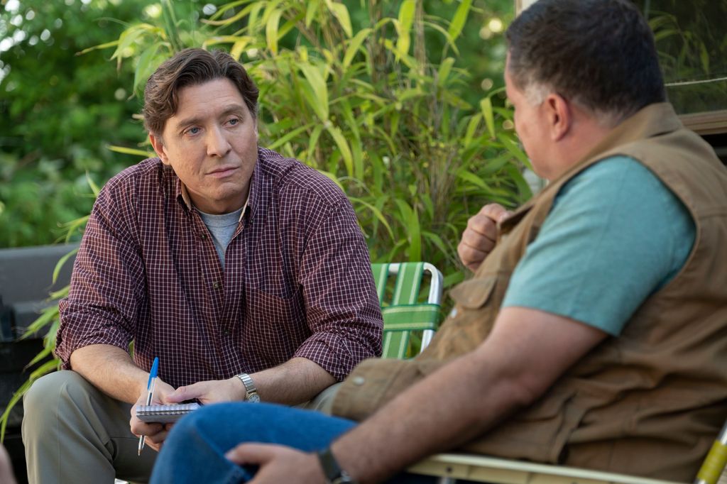 two men sitting on deck chairs outdoors