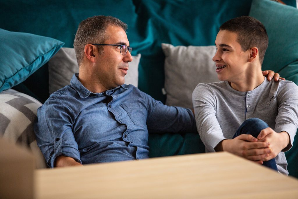 Teenage boy and his father talking