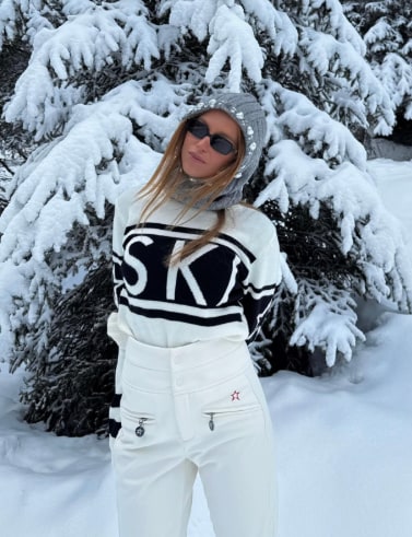woman in white ski trousers and jumper