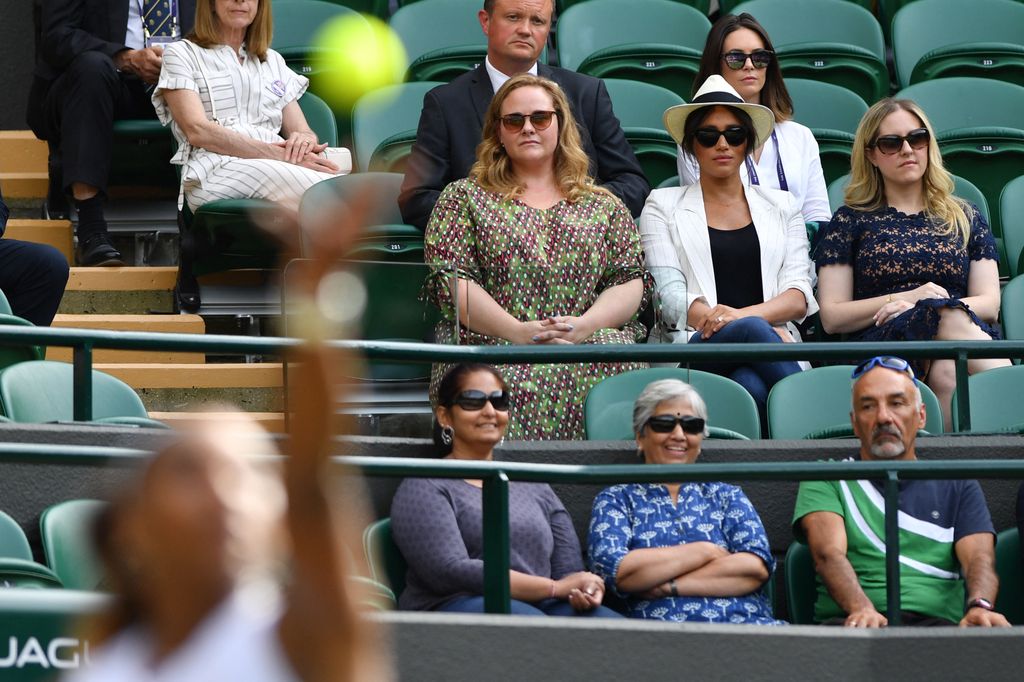 Meghan watching wimbledon with friends donning jeans and a hat 