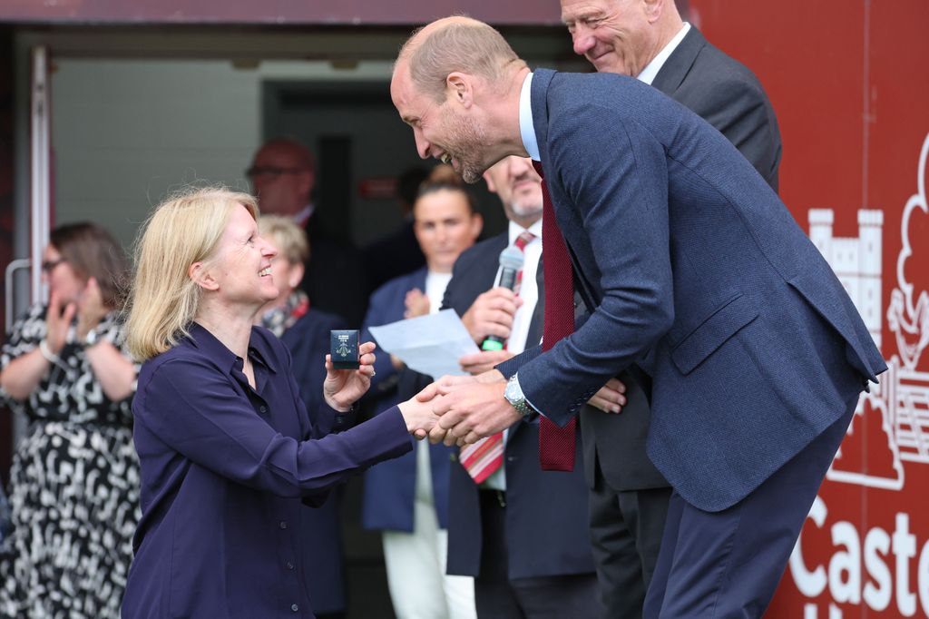 Prince William presents a brooch to a former player from the WRU's Missing Caps campaign