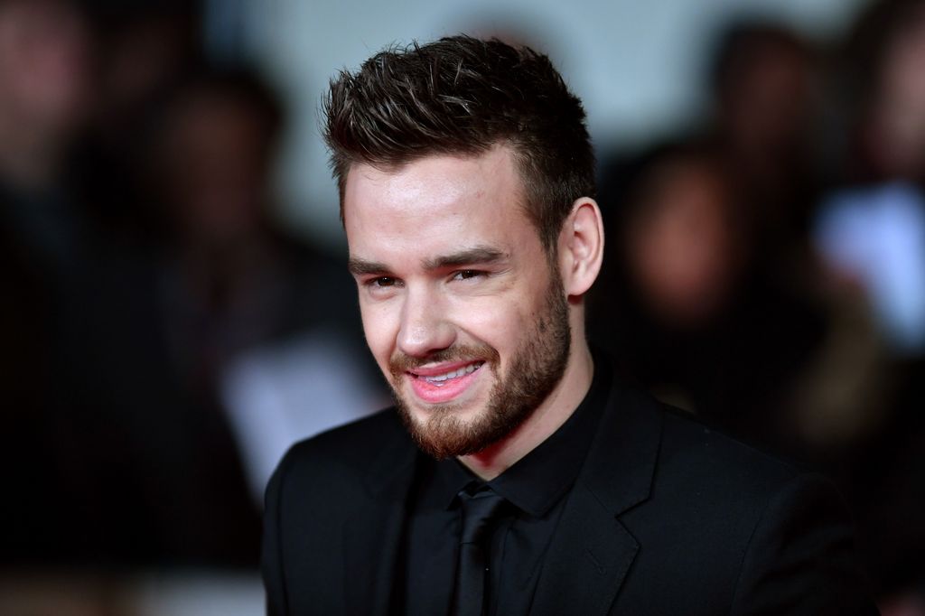 Liam Payne smiling in black suit