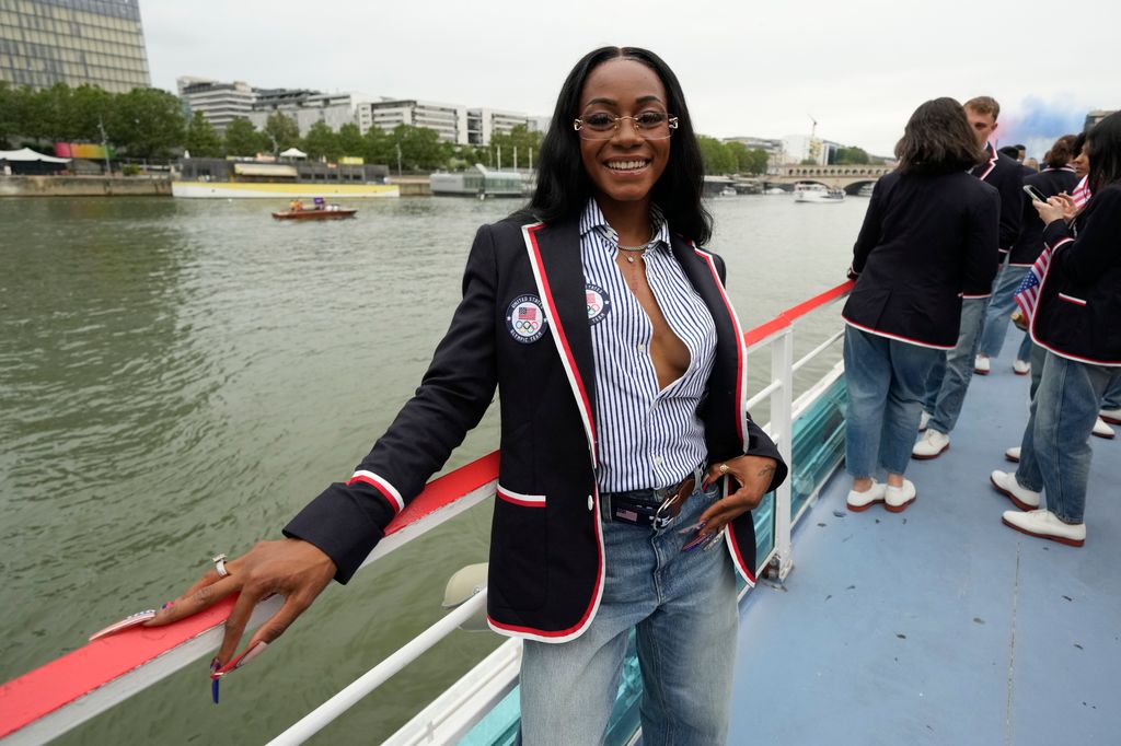 Sha'Carri Richardson poses for a photo while riding with teammates on a boat with teammates along the Seine River during the Opening Ceremony of the Olympic Games Paris 2024 