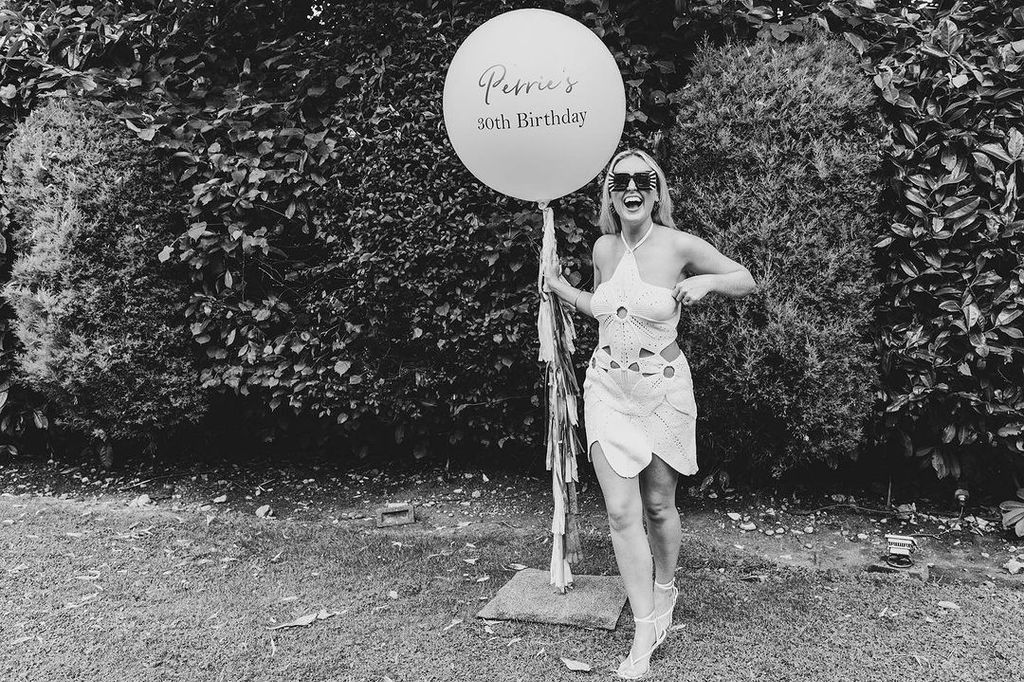 perrie holding a birthday balloon 