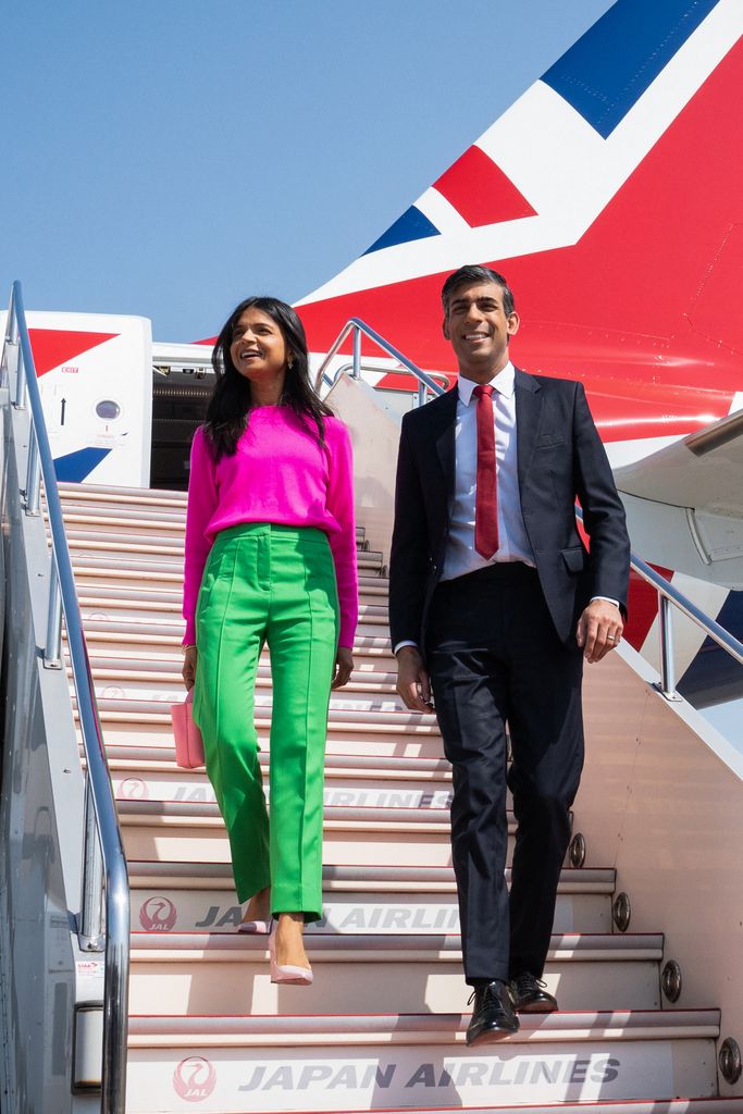 Britain's Prime Minister Rishi Sunak (R) and his wife Akshata Murty disembark their plane upon their arrival at the Tokyo Airport ahead of the G7 Leaders' Summit, on May 18, 2023.