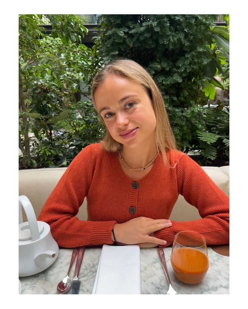 Amelia Windsor wearing an orange cardigan whilst at a hotel