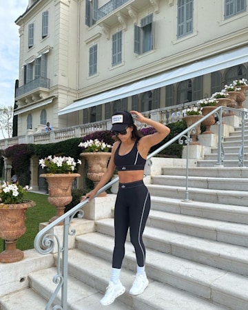 Woman Wearing White Sports Bra and Gray Pants Laying on Stairway