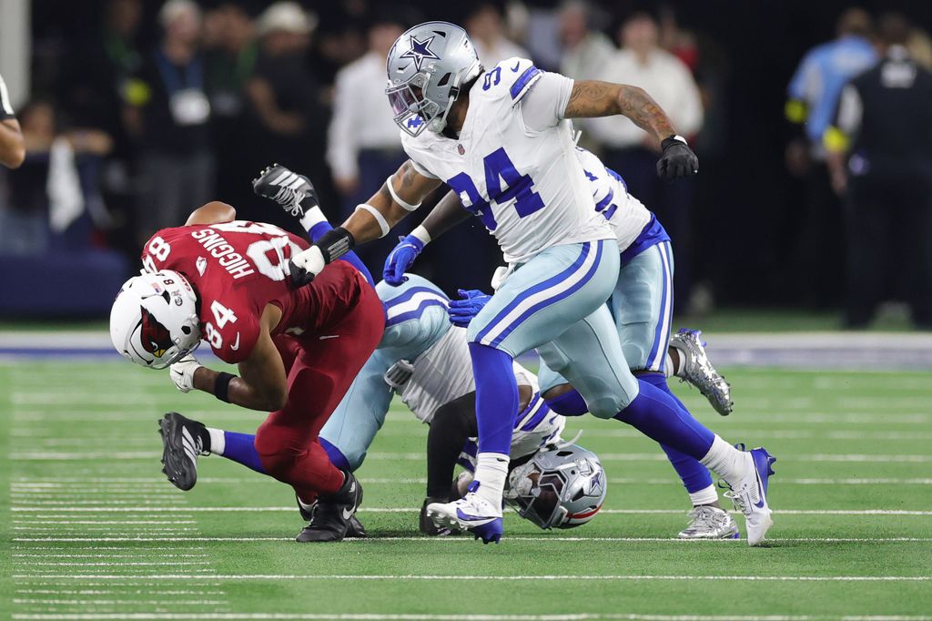 Elijah Higgins #84 of the Arizona Cardinals rushes ahead of Marshawn Kneeland #94 of the Dallas Cowboys during the second quarter in the game at AT&T Stadium on November 03, 2025 in Arlington, Texas