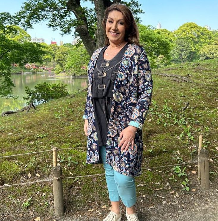 Jane McDonald in floral coat standing in a park
